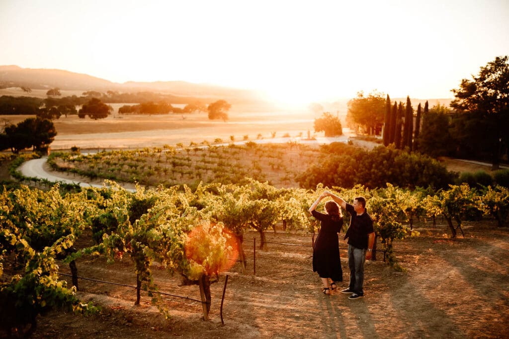 Couple dancing in a vineyard at sunset