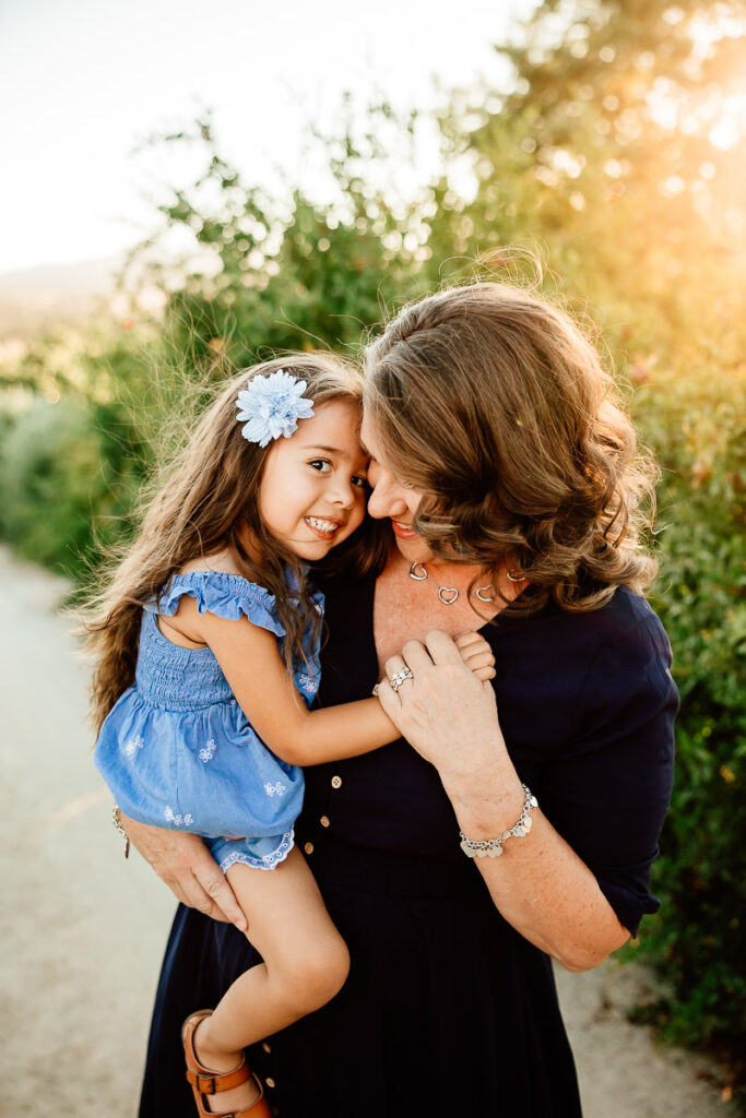backlit image of grandma holding young granddaughter
