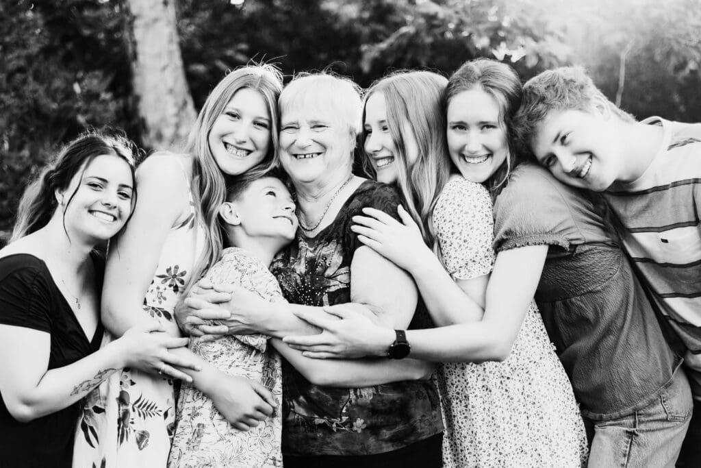 black and white portrait of a grandmother surrounded by her teen and dult grandchildren