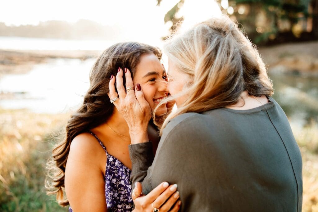 mom and adult daughter share eskimo kisses