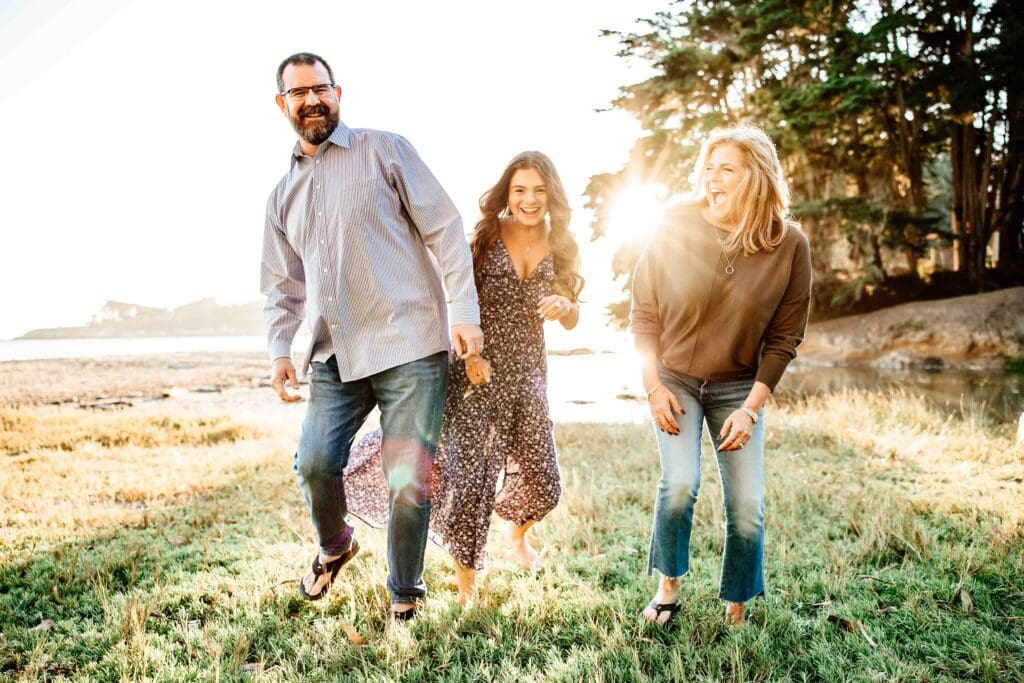 Backlit joyful photo of a family with an older teen daughter for a blog post about the importance of family photos as your kids get older
