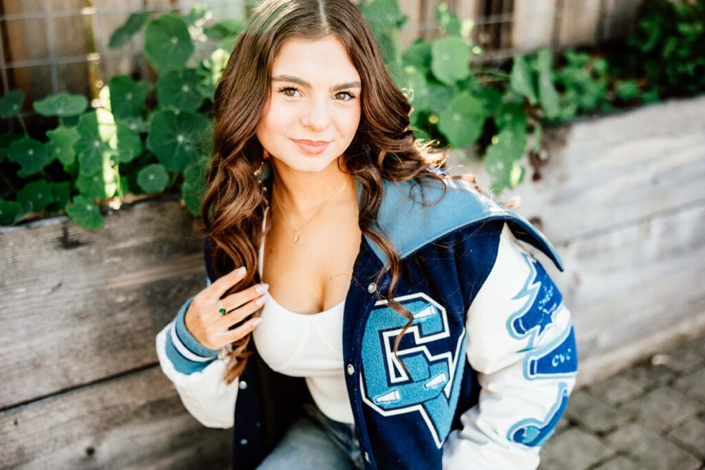 Up close portrait of a senior girl wearing her letterman's jacket for a blog post about the importance of senior photos