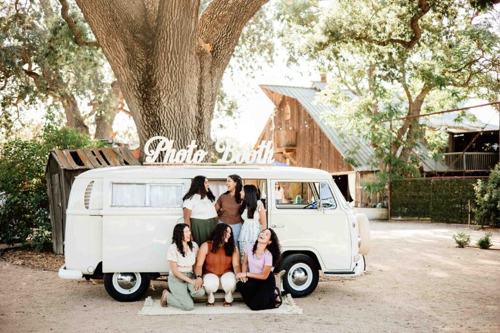 Group of girls laughing in front of Bessy the Foto Bus at a graduation party in Templeton, cA