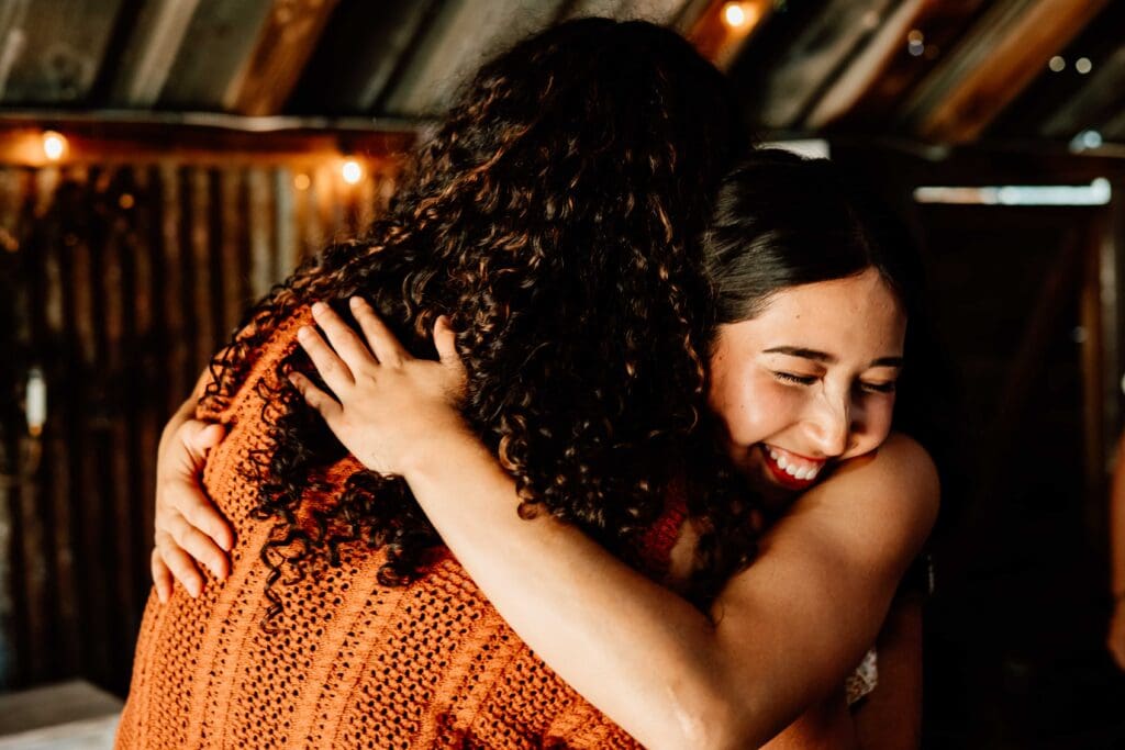 Cousins embracing at a graduation party at Oak & Ivy in Templeton, CA