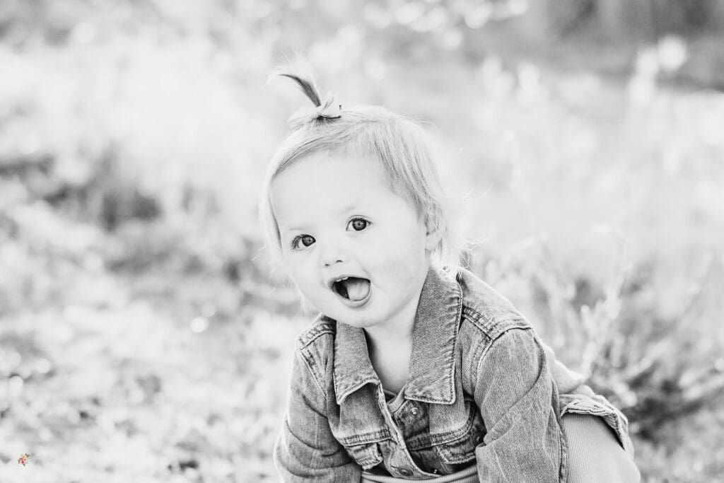 black and white image of a baby girl smirking