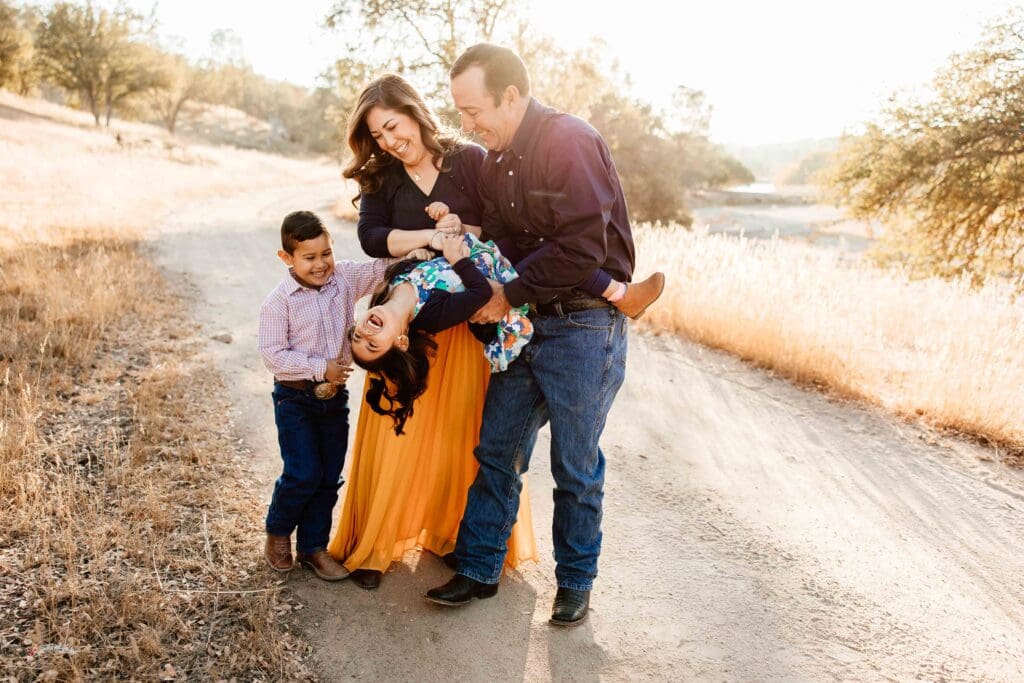Backlit image of a family of 4 being playful for a blog post about Family Photo Session