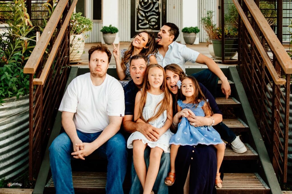 Family photo on a porch with everyone making faces