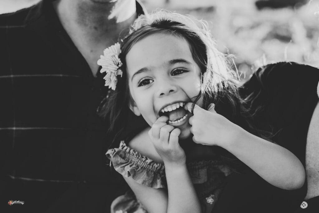 black and white image of a little girl happy and making a face