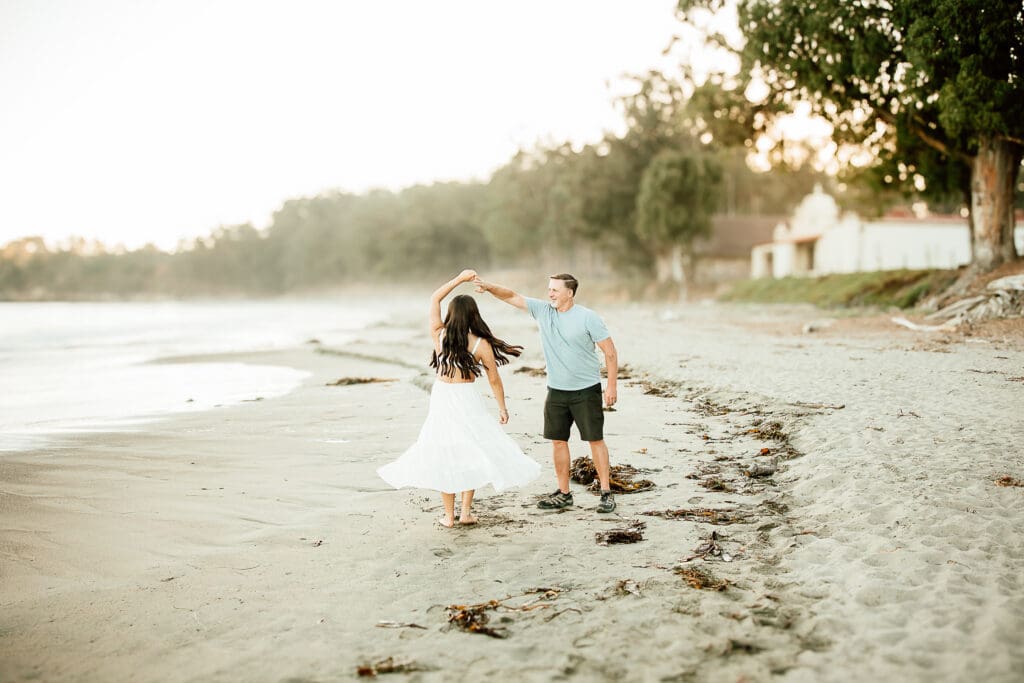 Father and adult daughter dancing on the beach